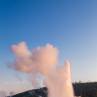 Old Faithful geyser eruption at sunrise
