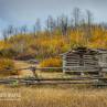 Two abandoned old log cabins with wooden fence
